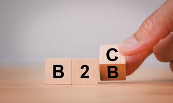 3 blocks spelling B, 2, C. Fingers are turning the last B into a C